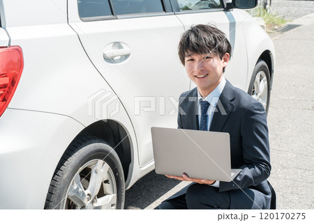 中古車を査定する営業マン・中古車査定士のスーツ姿の若いアジア人男性 中古車を査定する営業マン・中古車査定士のスーツ姿の若いアジア人男性 120170275