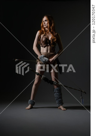 A poised warrior stands confidently in a creative studio during a dramatic shoot A poised warrior stands confidently in a creative studio during a dramatic shoot 120170347