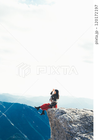 生石高原の火上げ岩に座る女性 120172197