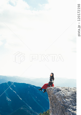 生石高原の火上げ岩に座る女性 120172198