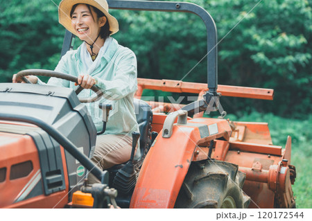 トラクターの運転をする女性 120172544