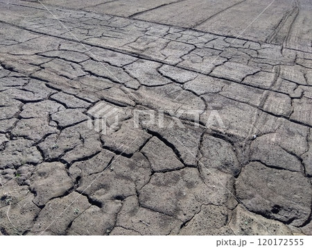 晩秋のひび割れた黒い畑風景 120172555