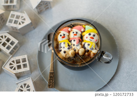 Cup of coffee with marshmallows. Marshmallow snowman in a Santa Claus hat. Winter drink. Christmas sweet food. Top view Cup of coffee with marshmallows. Marshmallow snowman in a Santa Claus hat. Winter drink. Christmas sweet food. Top view 120172733