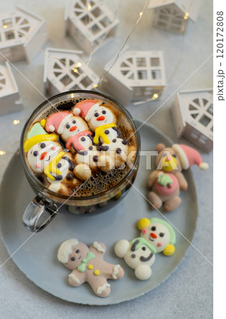 Cup of coffee with marshmallows. Marshmallow snowman in a Santa Claus hat. Winter drink. Christmas sweet food. Top view 120172808