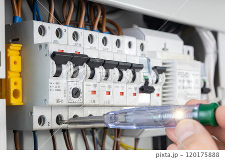 Electrician Testing Circuit Breakers with Voltage Tester 120175888