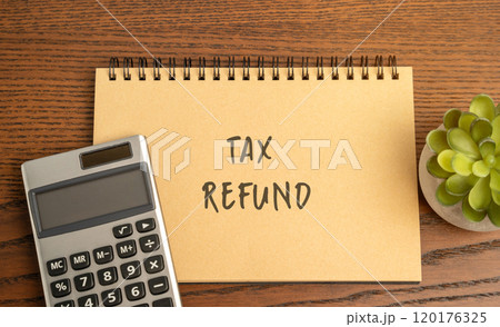 Tax refund concept - return of excess taxes paid to the government by a taxpayer. Business and finance. Notebook with inscription and calculator 120176325