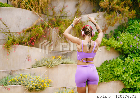 A Fit and Active Woman Dressed in Stylish Purple Workout Gear at a Beautiful Scenic Outdoor Location A Fit and Active Woman Dressed in Stylish Purple Workout Gear at a Beautiful Scenic Outdoor Location 120176373