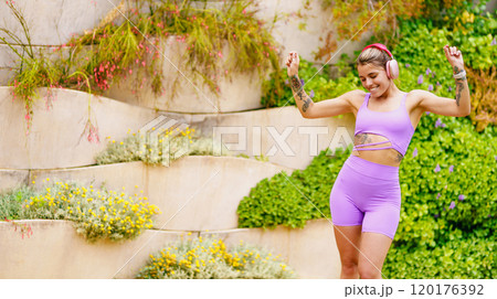 A Joyful Fitness Enthusiast Dancing Gracefully in the Beautiful Embrace of Nature 120176392