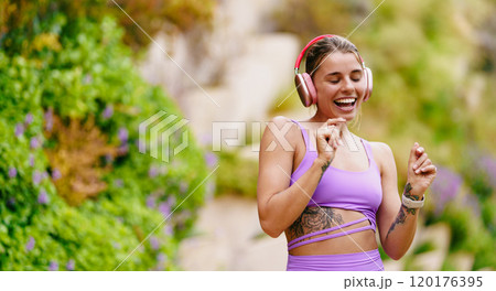 A Joyful Woman Dancing Outdoors with Headphones, Celebrating Life and Movement in Nature 120176395