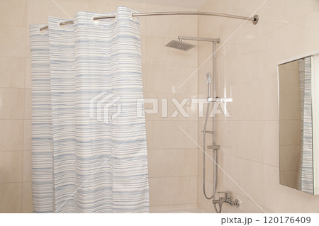 Front view of Modern Bathroom Interior with corner shower curtain. Bathroom interior with chrome faucet 120176409