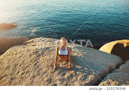 Yoga makes everything seem better. Shot of an athletic young woman practicing yoga on the beach. 120176546