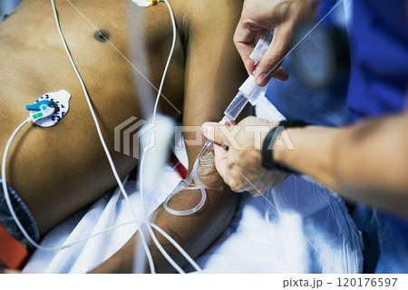 Drug administration via an iv drip. Cropped shot of a doctor inserting an iv drip into a patients arm in an emergency room. 120176597