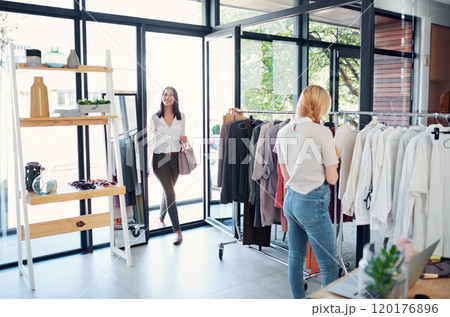 Checking out the new boutique. Shot of two young women shopping in a clothing store. Checking out the new boutique. Shot of two young women shopping in a clothing store. 120176896