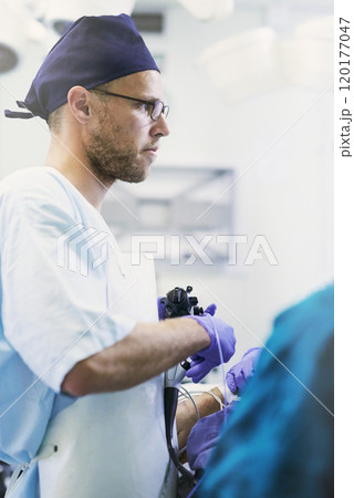 Life saving is what he does. Shot of a young surgeon performing surgery on a patient in an operating room. Life saving is what he does. Shot of a young surgeon performing surgery on a patient in an operating room. 120177047