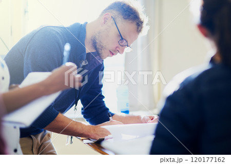Paperwork is part of the job. Shot of a young doctor filling out paperwork in a hospital. 120177162