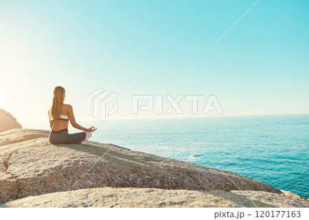 Ill never skip a session. Rearview shot of a young woman practicing yoga on the beach. 120177163