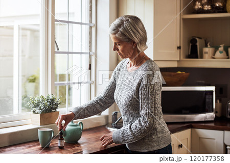 Time to take my medicine. Cropped shot of a relaxed senior woman preparing a cup of tea with CBD oil inside of it at home during the day. Time to take my medicine. Cropped shot of a relaxed senior woman preparing a cup of tea with CBD oil inside of it at home during the day. 120177358