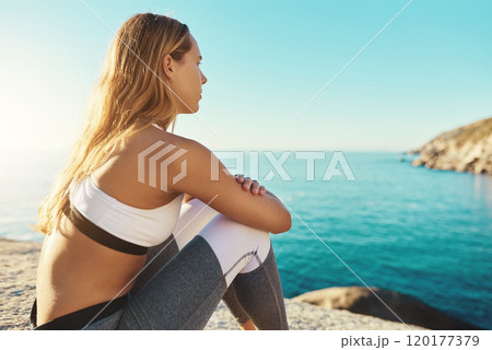 Now its time to just take in the view. Shot of an athletic young woman practicing yoga on the beach. 120177379