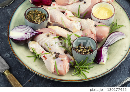 Raw chicken leg pieces with spices. 120177433