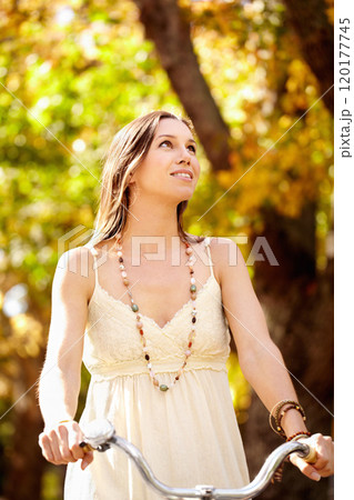 Autumn beauty. Shot of an attractive young woman in the park on an autumn day. 120177745