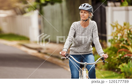Where should I go now. Cropped shot of a cheerful senior woman riding on a bicycle by herself outside in a suburb. 120177789