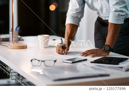 Putting pen to paper on some important issues. Shot of an unrecognizable businessman filling out some paperwork while working late in his office. 120177896