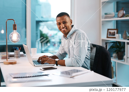 Success is a mentality. Portrait of a handsome young businessman working on his laptop during a late night shift at work. 120177977