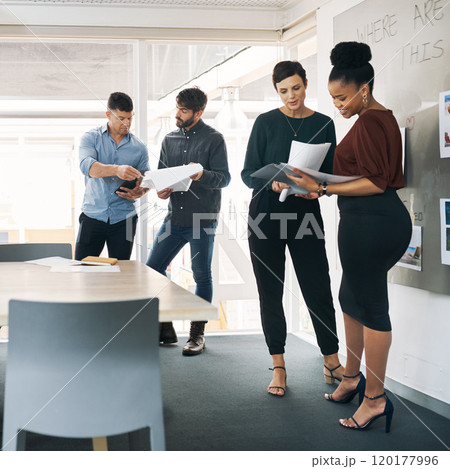 Take note of this awesome team. Shot of a group of businesspeople discussing paperwork during a meeting in a modern office. Take note of this awesome team. Shot of a group of businesspeople discussing paperwork during a meeting in a modern office. 120177996