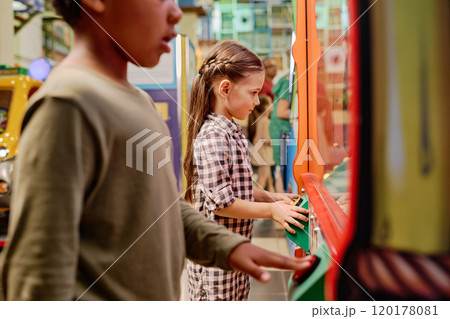 Little girl trying to crane soft toy Little girl trying to crane soft toy 120178081