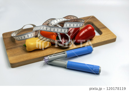 Ozempic Insulin injection pen for diabetics and weight loss and a cutting board with vegetables and a measuring tape. 120178119