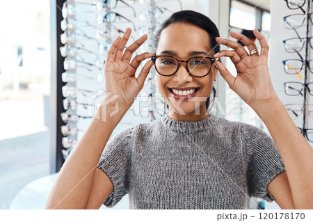 The best eyewear brands in the optometry business. Shot of a young woman buying a new pair of glasses at an optometrist store. 120178170