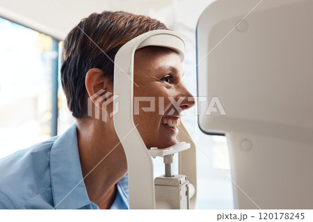 See your best with an annual eye test. Shot of a young woman getting her eyes examined with an autorefractor. 120178245
