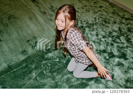 Little girl sitting by soft green slide 120178303