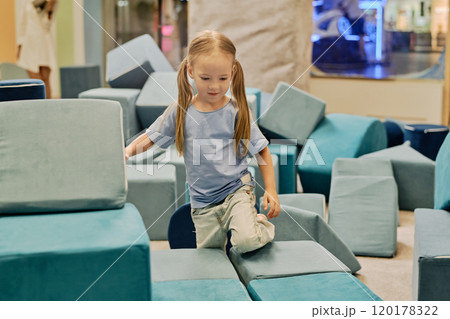 Girl playing with big soft toy cubes 120178322