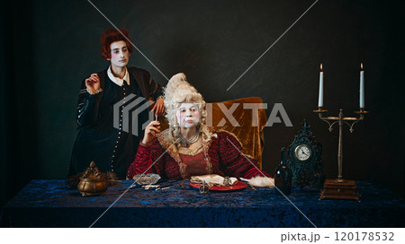 Elderly woman, royal person, countess in period attire sitting at table and smoking, young man, court servant standing near. 120178532