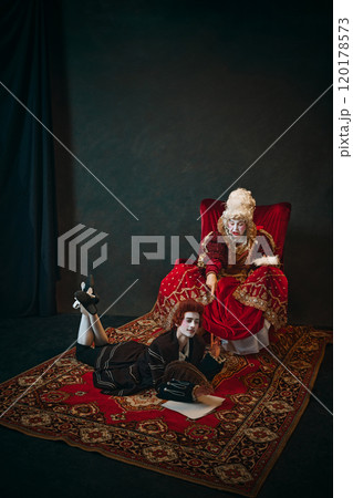 Emotional elderly woman, medieval royal person, queen sitting and commanding to young man, court servant writing letter with dreamy thoughtful face Emotional elderly woman, medieval royal person, queen sitting and commanding to young man, court servant writing letter with dreamy thoughtful face 120178573