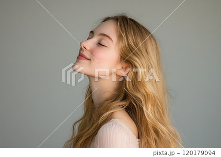 Blonde woman relaxing with her eyes closed in soft lighting 120179094