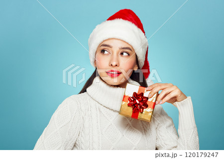 Beautiful woman in a white knitted sweater with gift box 120179247