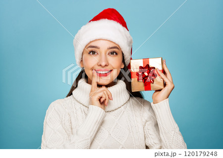 Beautiful woman in a white knitted sweater with gift box 120179248