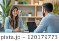 Woman smiling while having a discussion with a colleague at work 120179773