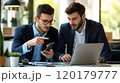 Two businessmen collaborating over a smartphone and laptop 120179777