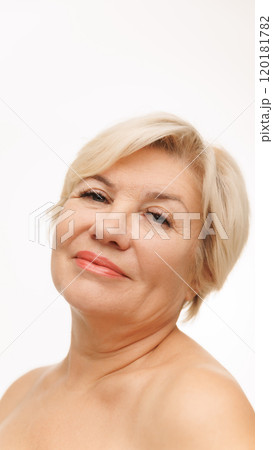 Self-care. Her gentle gaze and smooth skin reflect commitment to healthy living and natural beauty against white studio background. Self-care. Her gentle gaze and smooth skin reflect commitment to healthy living and natural beauty against white studio background. 120181782