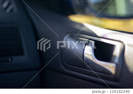 This is a detailed close up of a door handle found in a car This is a detailed close up of a door handle found in a car 120182240