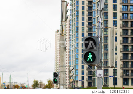 There is a pedestrian crossing sign positioned next to a traffic light There is a pedestrian crossing sign positioned next to a traffic light 120182333