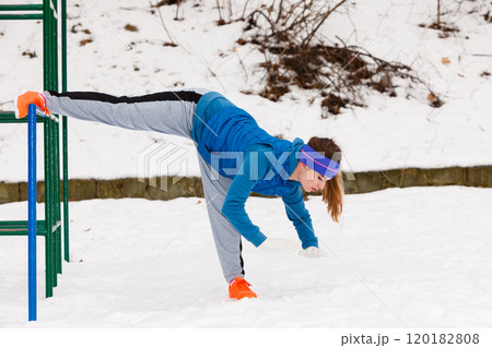 Woman wearing sportswear urban exercising outside during winter Woman wearing sportswear urban exercising outside during winter 120182808