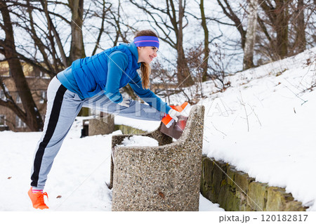 Woman wearing sportswear exercising outside during winter Woman wearing sportswear exercising outside during winter 120182817