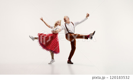 Senior couple, stylish man in suspenders and elegant woman in polka dot dress, dynamically dancing isolated on white background 120183532