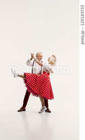 Senior man and woman engage in lively dance, dressed in vintage-inspired clothing isolated on white background 120183555