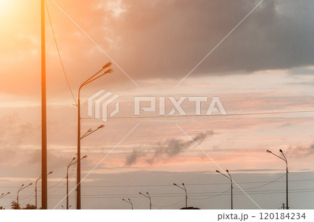 Sunset sky with a few clouds and a street lights silhouette Sunset sky with a few clouds and a street lights silhouette 120184234