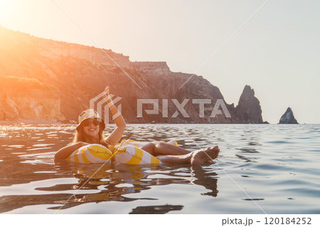 Woman, Santorini, Float Woman floats on inflatable ring in Santorini's ocean. Woman, Santorini, Float Woman floats on inflatable ring in Santorini's ocean. 120184252